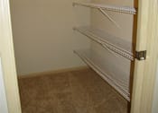 Thumbnail 3 of 12 - Empty shelves in a room with beige carpet.