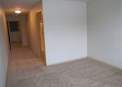 Thumbnail 10 of 12 - A room with a carpeted floor and a doorway leading to another room.