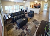Thumbnail 6 of 17 - A living room with a black leather couch and ottoman.