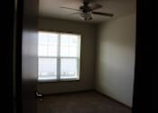 Thumbnail 16 of 17 - A room with a ceiling fan and a window.