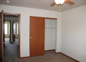 Thumbnail 11 of 17 - A room with a brown door and a ceiling fan.