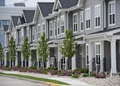 Thumbnail 1 of 17 - A row of houses with trees in front of them.