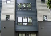 Thumbnail 15 of 17 - A modern house with a grey front and a small garden.