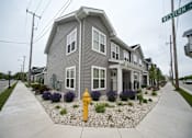 Thumbnail 2 of 17 - A grey house with a yellow fire hydrant in front.
