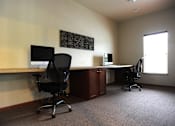 Thumbnail 7 of 17 - A room with a desk and two chairs.