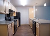 Thumbnail 16 of 21 - A kitchen with black appliances and wooden cabinets.