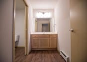 Thumbnail 18 of 21 - A bathroom with a wooden vanity and a mirror above it.
