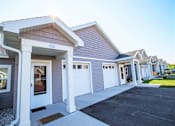 Thumbnail 1 of 21 - A row of houses with garages in front.