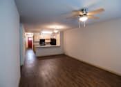 Thumbnail 20 of 21 - A room with a ceiling fan and wooden floors.