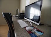 Thumbnail 8 of 21 - A computer desk with a monitor, keyboard, and mouse.