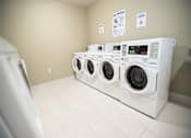 Thumbnail 10 of 13 - A row of washing machines in a laundromat.