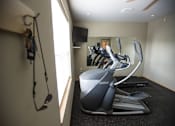 Thumbnail 12 of 13 - A home gym with a treadmill and exercise bike.