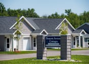 Thumbnail 5 of 13 - The image shows a sign for Beacon Avenue Cottages in front of a building.