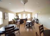 Thumbnail 8 of 13 - A well-lit dining room with a table and chairs.
