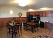 Thumbnail 12 of 15 - A kitchen with a table and chairs in the middle of the room.