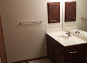 Thumbnail 9 of 15 - A bathroom with a sink, mirror, and towel rack.