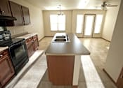 Thumbnail 6 of 15 - A kitchen with a black oven and wooden cabinets.