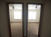 Thumbnail 10 of 15 - A room with a carpet floor and a ceiling fan.
