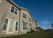 Thumbnail 2 of 15 - A row of houses with grey siding and white trim.