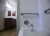 Thumbnail 19 of 21 - A white bathtub with a silver faucet and a silver grab bar.