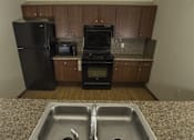 Thumbnail 9 of 21 - A kitchen with a black refrigerator, black oven, and black microwave.