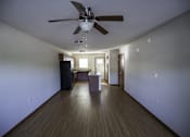 Thumbnail 20 of 21 - A room with a ceiling fan and wooden floors.