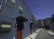 Thumbnail 8 of 21 - A long row of houses with blue siding and red doors.