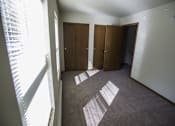 Thumbnail 1 of 21 - A room with a carpet and three wooden doors.