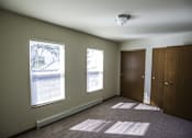 Thumbnail 14 of 21 - A room with two windows and a car parked outside.