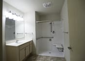 Thumbnail 20 of 22 - A bathroom with a sink, mirror, and shower.