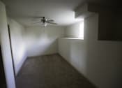 Thumbnail 21 of 22 - A room with a ceiling fan and a window.