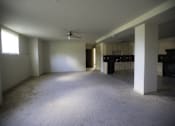 Thumbnail 15 of 22 - A spacious living room with a ceiling fan and a kitchen in the background.