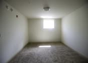 Thumbnail 14 of 22 - A room with a window and carpeted floor.