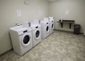 Thumbnail 8 of 22 - A row of washing machines in a laundromat.