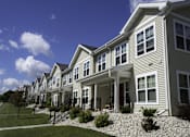 Thumbnail 4 of 22 - A row of houses with a blue sky in the background.