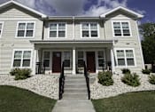 Thumbnail 6 of 22 - A two-story house with a red door and a front porch.