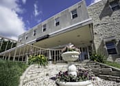 Thumbnail 3 of 22 - A stone building with a white awning and a fountain in front.