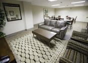 Thumbnail 9 of 22 - A living room with a black and white patterned rug.