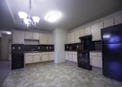 Thumbnail 22 of 22 - A kitchen with black appliances and white cabinets.