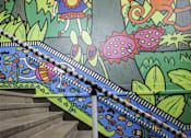 Thumbnail 10 of 27 - A staircase with a painted jungle scene on the wall.