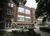 Thumbnail 15 of 27 - A large brick building with a white door and windows.