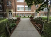 Thumbnail 16 of 27 - A brick building with a tree in front.