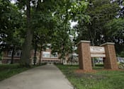 Thumbnail 19 of 27 - A brick sign that says Elementary School is in front of a building.