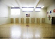 Thumbnail 1 of 27 - A gym with a basketball court and a flag hanging on the wall.