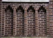 Thumbnail 23 of 27 - A wall made of bricks with three arched windows.