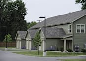 Thumbnail 26 of 27 - A house with a grey roof and a green lawn.