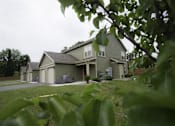 Thumbnail 27 of 27 - A house with a grey roof and a green lawn.