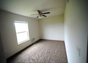 Thumbnail 5 of 13 - A room with a ceiling fan and a window.