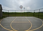 Thumbnail 10 of 13 - A basketball court with a basketball hoop and a light pole.
