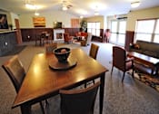 Thumbnail 7 of 13 - A dining room with a wooden table and chairs.